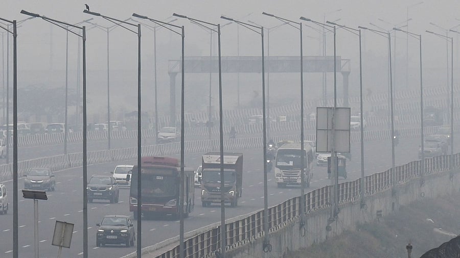 People commute along a street amid smoggy conditions in New Delhi. Credit: AFP Photo