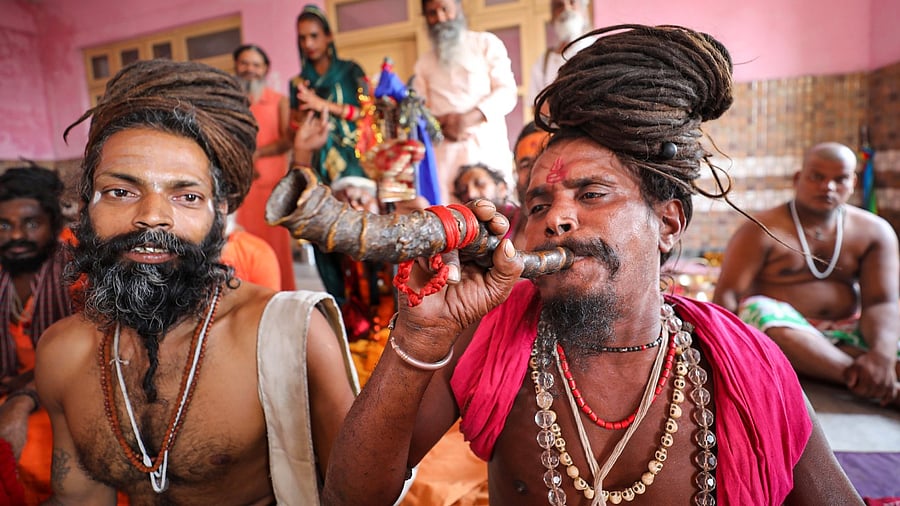 Sadhus pose for pictures after arriving at the base camp of Amarnath Yatra. Credit: PTI Photo