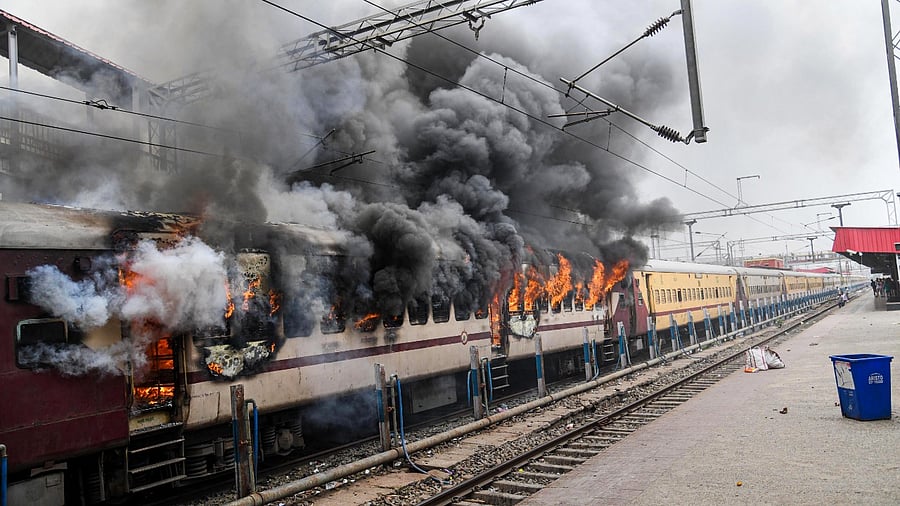 A train set ablaze by a mob in protest against the 'Agnipath' scheme. Credit: PTI Photo