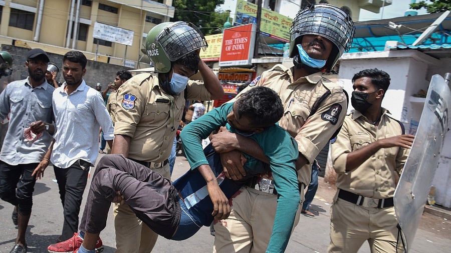 Policemen carried an injured protestor during a protest against Agnipath scheme in Secunderabad. Credit: Reuters Photo