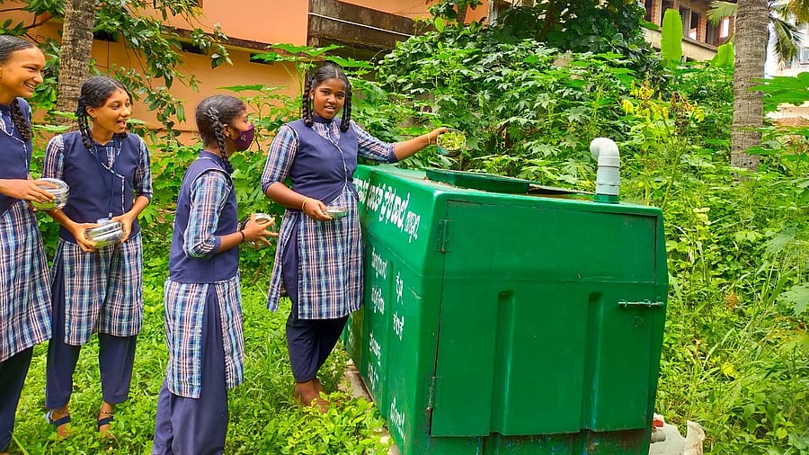 Students of Aided Bharath High School in Ullal dump wet waste into a bin for converting it into manure. Credit: DH Photo