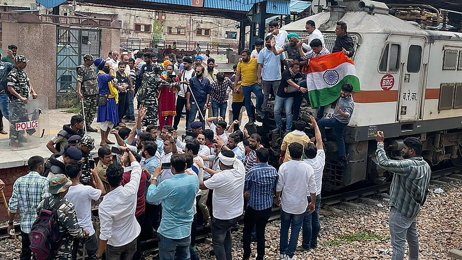 Members of Indian Youth Congress (IYC) stop a train at Shivaji Bridge as they protest over ED's probe against Rahul Gandhi in the National Herald case and Centre's 'Agnipath' scheme. Credit: PTI Photo
