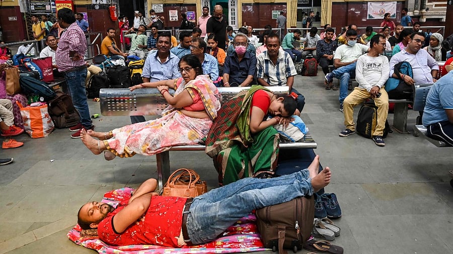 Passengers wait at a train station due to delay and rescheduling of a few trains after the rail network was damaged in some parts of the country following Agnipath protests. Credit: AFP Photo