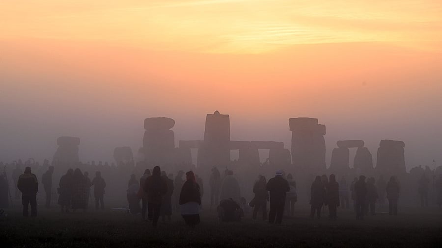 Revellers celebrate the Summer Solstice as the sun rises at Stonehenge. Credit: AFP Photo