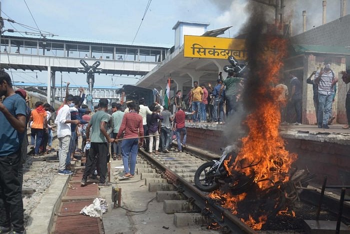 Protesters set ablaze a two-wheeler during a protest against Agnipath Recruitment Scheme, at Secunderabad railway station in Secunderabad. Credit: IANS Photo