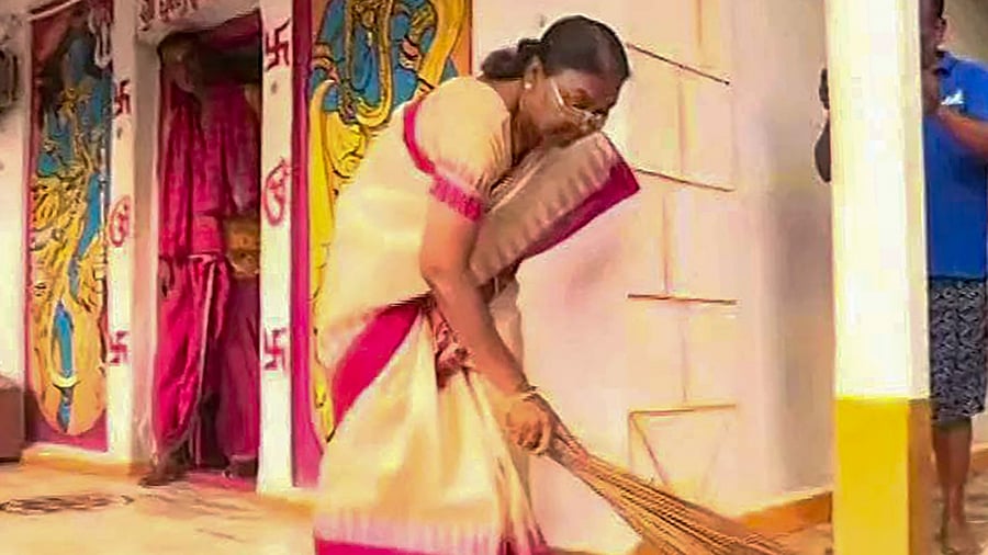 Former Jharkhand governor Draupadi Murmu, who has been chosen as the BJP-led NDA's candidate for presidential elections, sweeps at the Purnandeswar Shiv temple in Rairangpur, Mayurbhanj district, Odisha. Credit: PTI Photo
