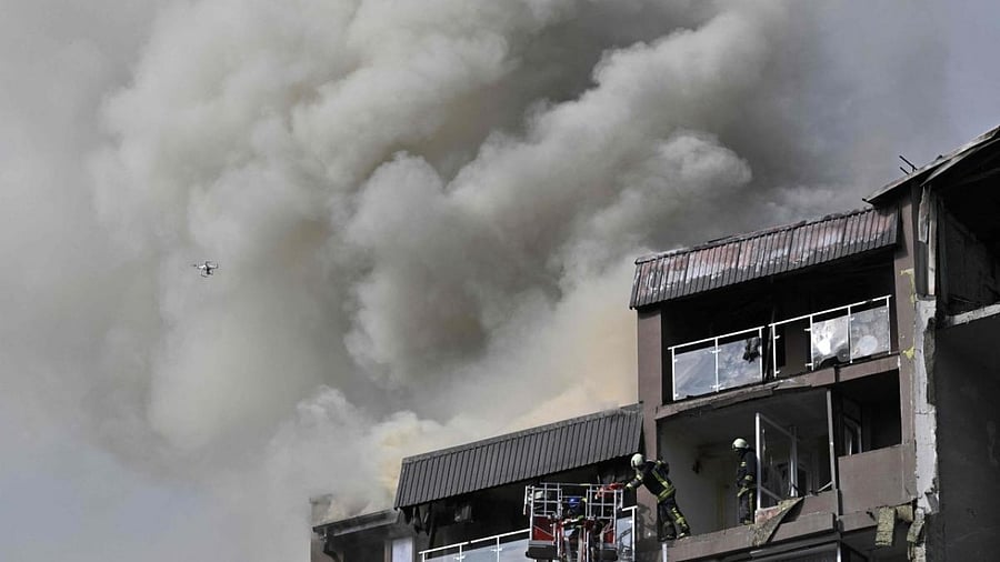 Rescuers and firefighters work in a damaged residential building, hit by Russian missiles in Kyiv. Credit: AFP Photo