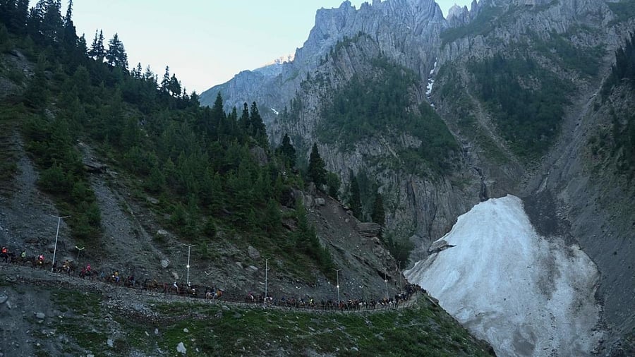 Hindu devotees make their way on foot, riding horses and carried by porters along a mountain path during their pilgrimage to the cave shrine of Amarnath, near Baltal on June 30, 2022. Credit: AFP Photo