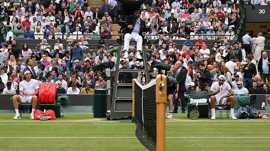 Australia's Nick Kyrgios (R) eats a banana during his men's singles tennis match against Greece's Stefanos Tsitsipas (L) on the sixth day of the 2022 Wimbledon Championships. Credit: AFP Photo