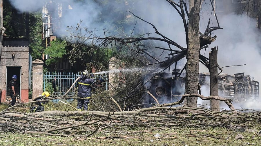Firefighters extinguish fire on a car after an air strike in the courtyard of hotel Industria and civilian residences in the center of Kramatorsk. Credit: AFP Photo