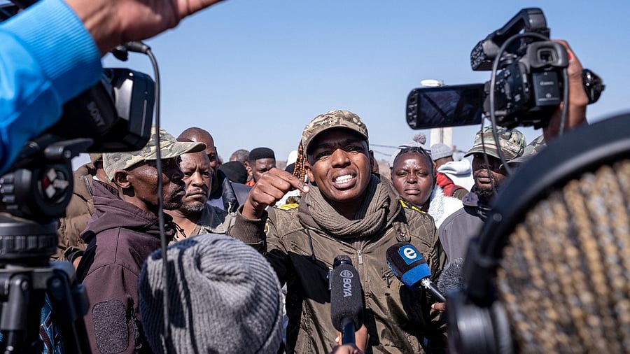 Nhlanhla Lux Mohlauli (C) addresses residents outside a crime scene where 15 people where shot dead in a tavern in Soweto. Credit: AFP Photo
