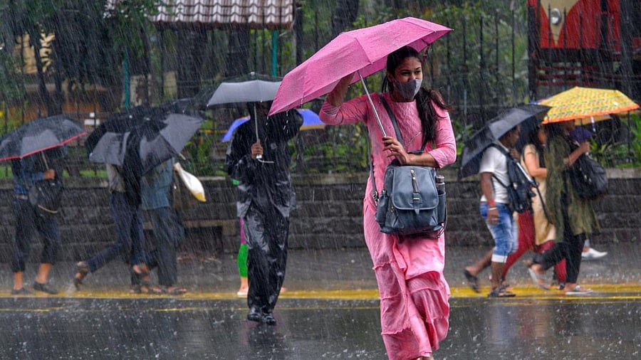 Commuters make their way through a street amidst heavy rainfall in Mumbai on July 13, 2022. Credit: AFP Photo