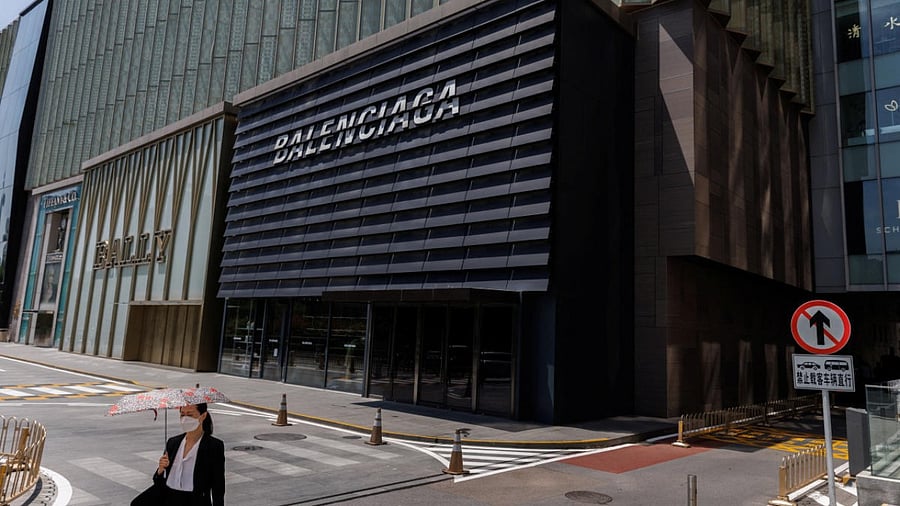 A woman walks near Ballly and Balenciaga boutiques in a shopping area in Beijing. Credit: Reuters