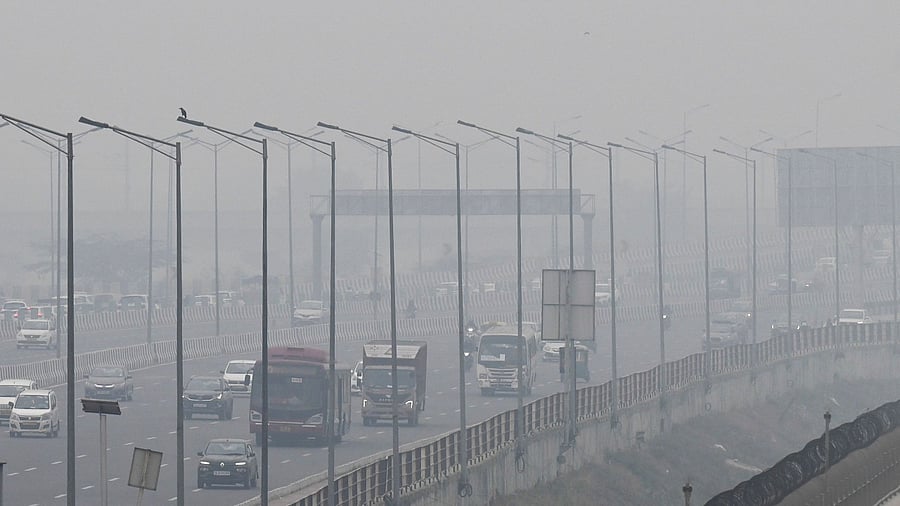 People commute along a street amid smoggy conditions in New Delhi on December 2, 2021. Credit: AFP File Photo