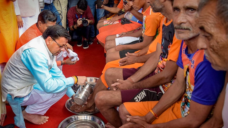 Haridwar: Uttarakhand Chief Minister Pushkar Singh Dhami welcomes Kanwariyas (Lord Shiva devotees) at the Har Ki Pauri ghat by washing their feet, during the holy month of 'Shravan', in Haridwar, Wednesday, July 20, 2022. Credit: PTI Photo