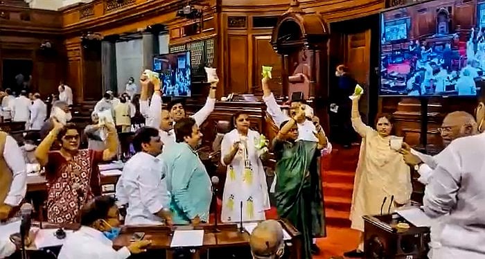 Opposition members stage a protest in the well of the Rajya Sabha against inflation and the Union Government's decision to increase GST on food items, during ongoing Monsoon Session. Credit: PTI Photo