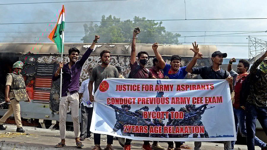 Protesters shout slogans after setting a train on fire during a demonstration against the government's new 'Agnipath' recruitment scheme for the army, navy, and air forces at a railway station in Secunderabad on June 17, 2022. Credit:AFP Photo