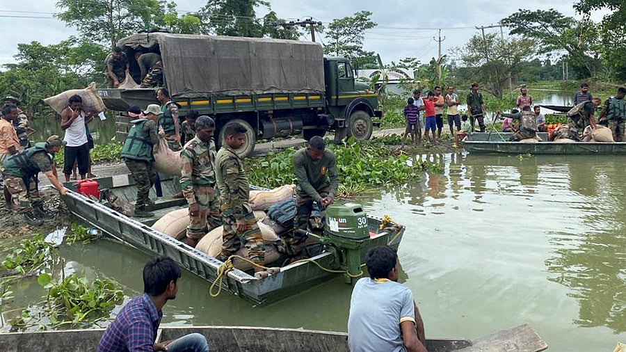 Indian Army's Assam Rifles personnel distribute relief material to residents of a flood-affected area, in Silchar. Credit: PTI Photo