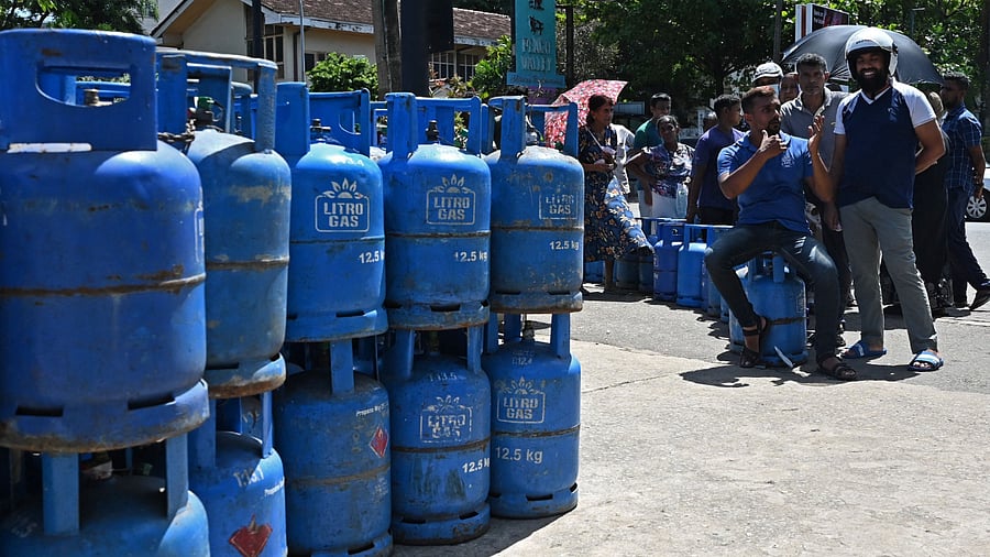 People wait in a queue to refill their Liquefied Petroleum Gas (LPG) cylinders at a gasoline distribution point in Colombo on July 14, 2022. Credit: AFP File Photo