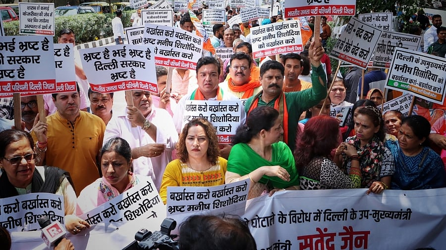 BJP workers and supporters hold placards participate in a protest against new excise policy outside AAP HQ in New Delhi. Credit: IANS Photo