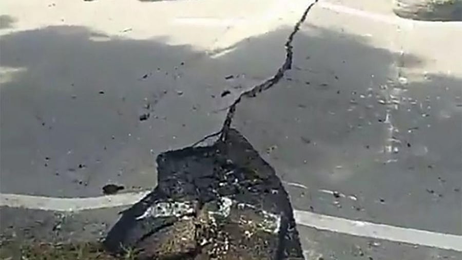 This handout video grab photo taken from the facebook page courtesy of CJ Ericson Garcia shows a resident walking past a crack on a road pavement in the town of Bangued, Abra province, north of Manila Manila on July 27, 2022, after a 7.1-magnitude earthquake hit the northern Philippines. Credit: AFP Photo