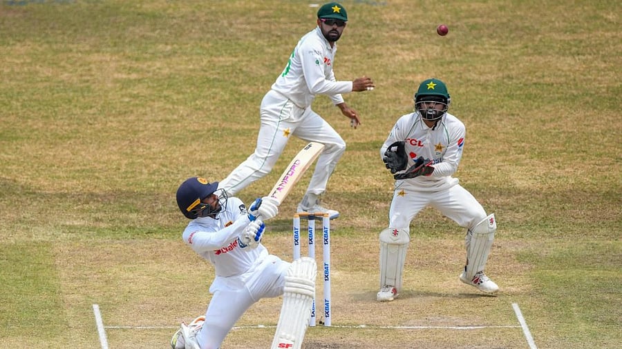 Sri Lanka's Dhananjaya de Silva (L) plays a shot as Pakistan’s wicketkeeper Mohammad Rizwan (R) and captain Babar Azam watch during the fourth day of the second cricket Test match. Credit: AFP Photo