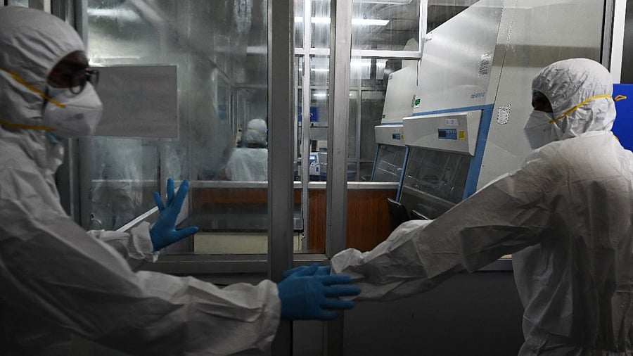 Technicians wearing personal protective equipment (PPE) suits are seen inside a molecular laboratory facility set up to test for the monkeypox disease. Credit: AFP Photo