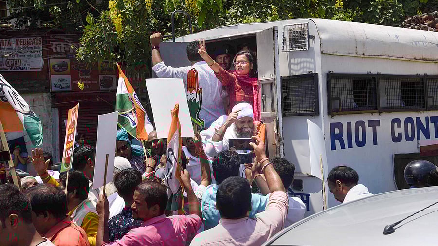 Congress workers shout slogans after being detained by police during their march towards Raj Bhavan. Credit: PTI Photo