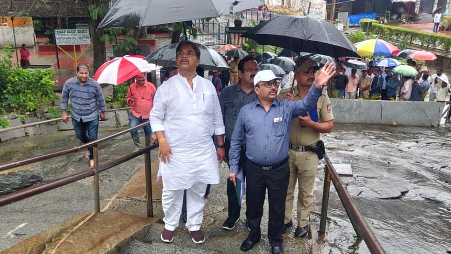 Revenue Minister R Ashoka inspects damage to the protection wall at the base of Vindhyagiri Hill at Shravanabelagola, Hassan district, following incessant rain, on Thursday. Credit: DH Photo