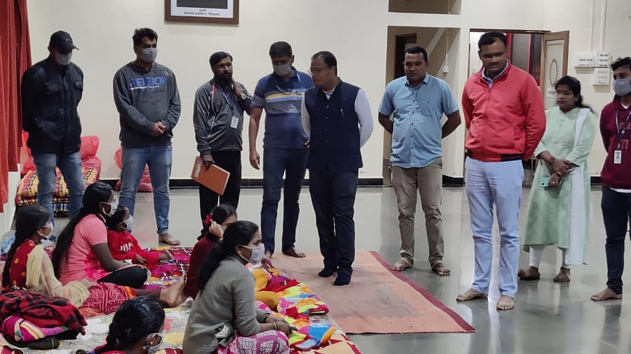 Deputy Commissioner Nitesh Patil talking with rain affected provided shelter in a relief centre at Kaivalya Yog Mandir, Tilakwadi in Belagavi on Monday night. Credit: DH Photo