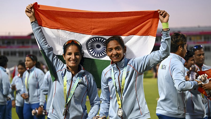 Silver medallist Indian women's cricket team players Harmanpreet Kaur and Renuka Singh hold the tricolor after the medal ceremony at the Commonwealth Games 2022. Credit: PTI Photo
