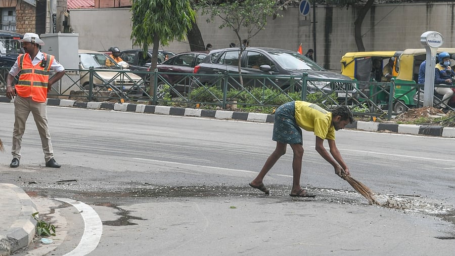 Workers clearing water on the road in Independence Day preparations at Central Street, Cubbon Road. Credit: DH Photo