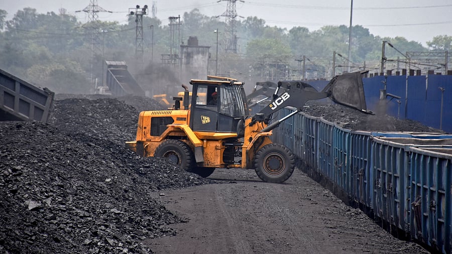 A worker operates a JCB machine to load coal onto a goods train at the Amrapali coal mines in Peeparwar in India's Jharkhand state on April 30, 2022. Credit: AFP File Photo