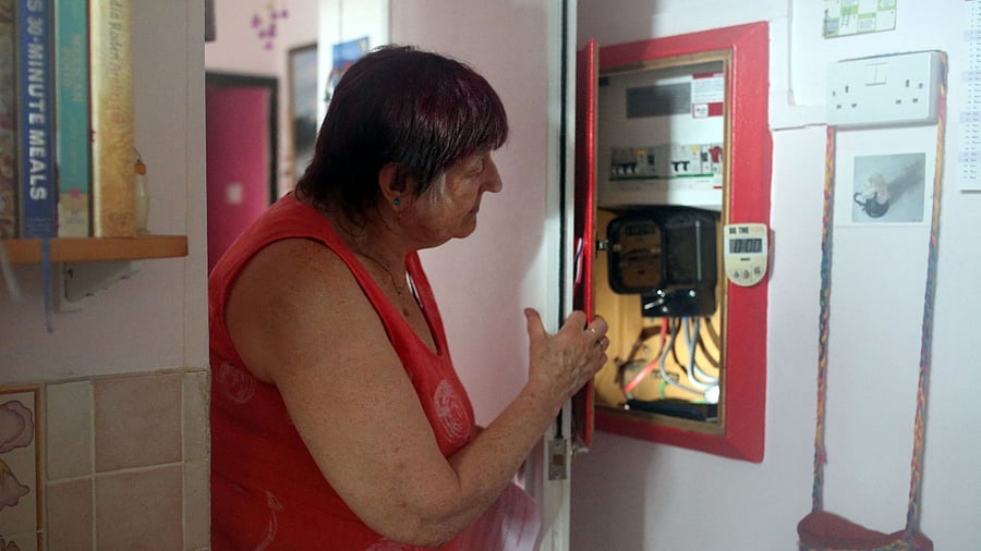 Pensioner Diane Skidmore examines her smart meter in London. Credit: AFP Photo
