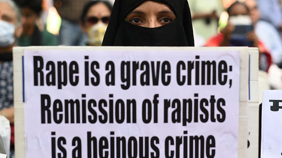 A demonstrator holds a placard during a protest against the release of men convicted of gang-raping of Bilkis Bano. Credit: AFP Photo