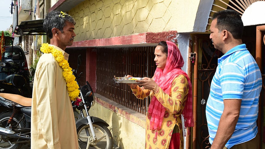 Kuldeep Kumar Yadav (L) who was imprisoned at a Pakistani jail since the year 1994 on espionage charges is greeted by his sister (C) and brother after his release. Credit: AFP Photo
