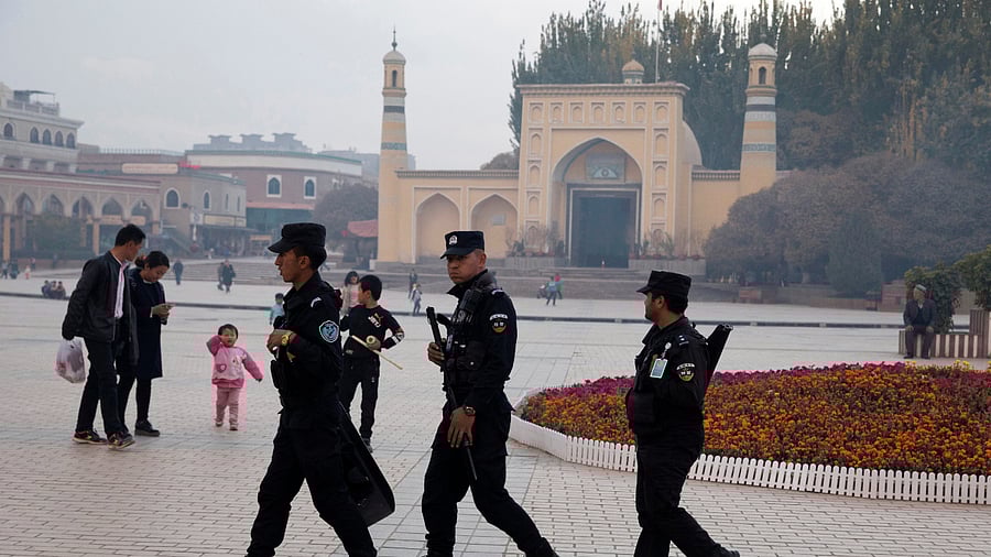 Uyghur security personnel patrol near the Id Kah Mosque in Kashgar in western China's Xinjiang region. Credit: AP File Photo