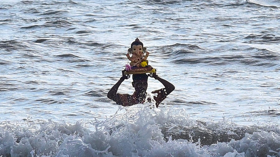 A volunteer carries a Ganesha idol for immersion. Credit: PTI Photo