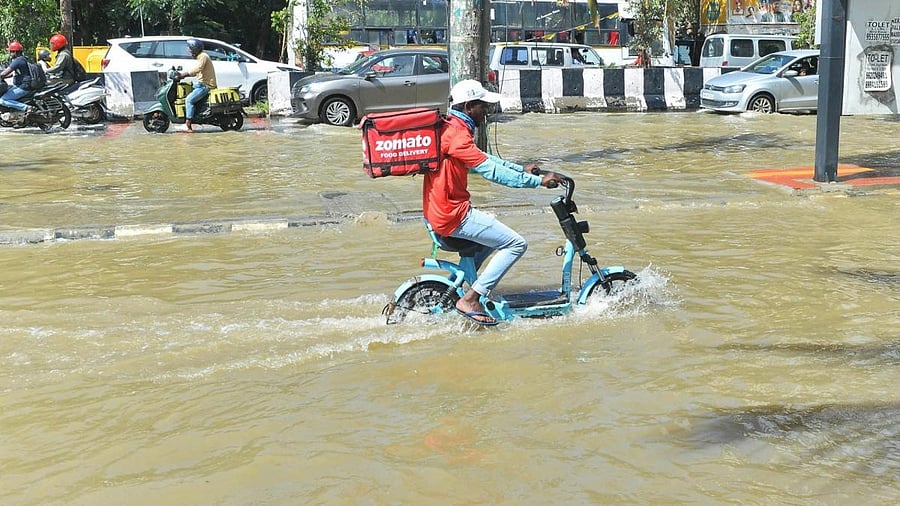A zomato delivery man passing through a waterlogged road after heavy monsoon rains in Bengaluru. Credit: IANS Photo