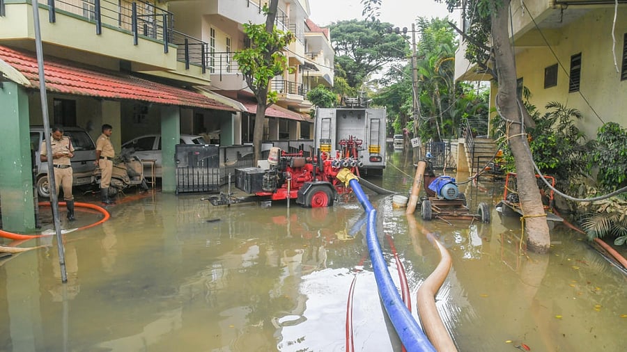 Firemen pump water out of Countryside Layout in Sarjapur on Thursday. Credit: DH Photo/S K Dinesh
