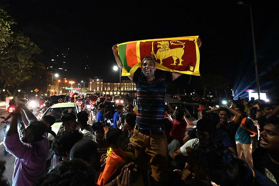 A Sri Lankan cricket fan celebrates Sri Lanka's victory by holding the nation's flag in Colombo on September 11, 2022, of the Asia Cup Twenty20 international cricket final match between Pakistan and Sri Lanka at the Dubai International Cricket Stadium in Dubai. Credit: AFP Photo