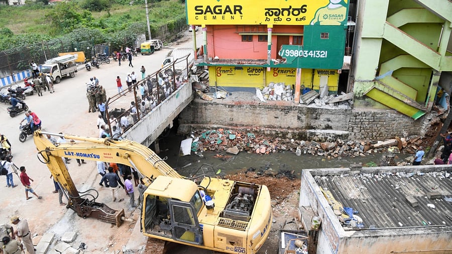 A demolition drive at the site of a rajakaluve encroachment at Rukmininagar in T Dasarahalli on Thursday. Credit: DH Photo