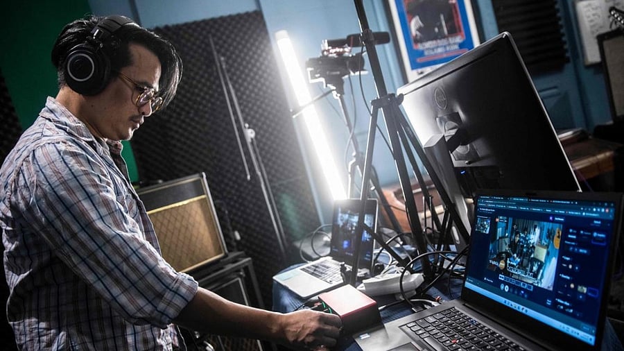 This picture taken on September 9, 2022 shows a technician checking equipment before live streaming a band's performance at a studio in Hong Kong. Credit: AFP Photo
