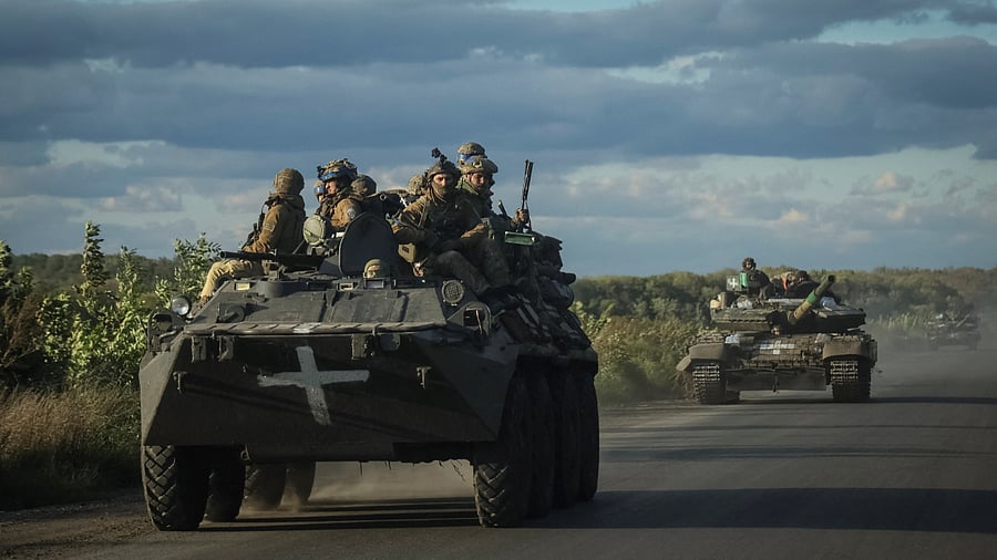 Ukrainian servicemen ride on Armoured Personnel Carrier (APC) and a tank near Izium, September 19, 2022. Credit: Reuters Photo