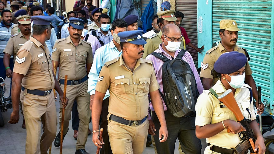 Officers of NIA with police personnel during a raid at the residence of a functionary of PFA, in Madurai. Credit: PTI Photo