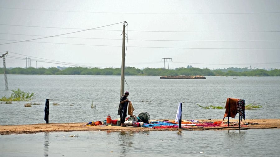 An internally displaced flood-affected man washes his clothes in a flood-hit area following heavy rains in Dera Allah Yar town of Jaffarabad district in Balochistan province. Credit: AFP Photo