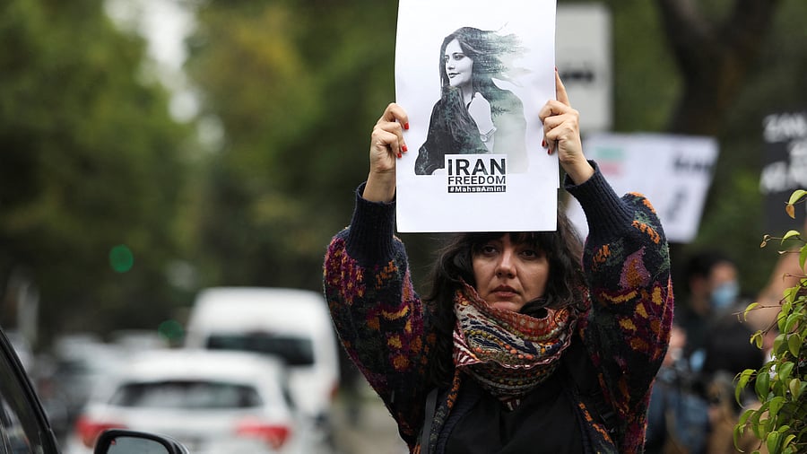 A woman holds up a sign during a protest against the Islamic regime of Iran and the death of Mahsa Amini, outside the Iranian embassy in Mexico City. Credit: Reuters Photo