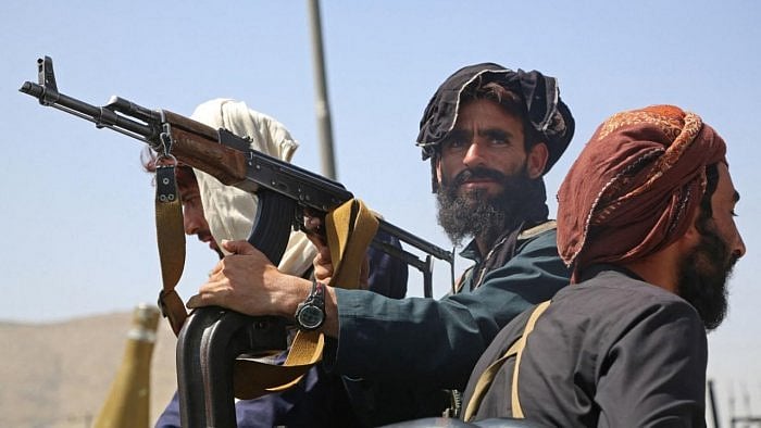 Taliban fighters stand guard in a vehicle along the roadside in Kabul. Credit: AFP Photo