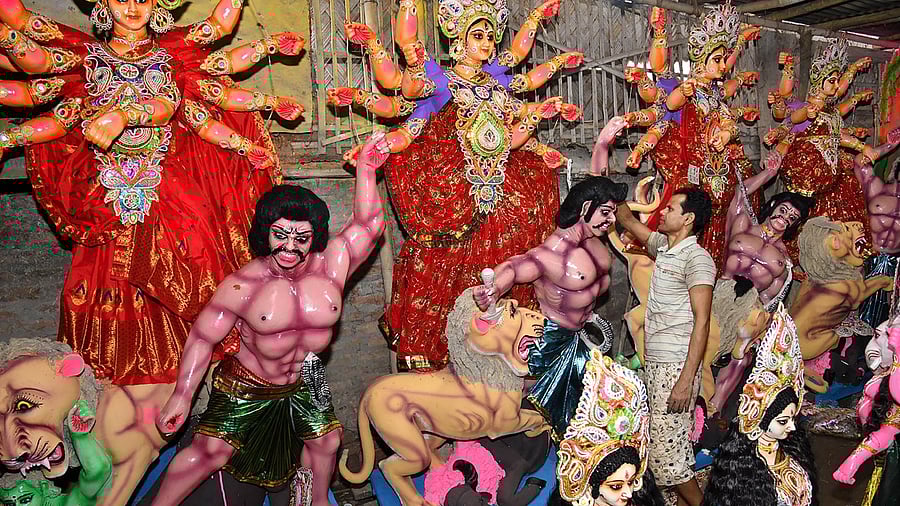 An artist gives finishing touches to an idol of Goddess Durga during ongoing Durga Puja festival, in Tezpur. Credit: PTI Photo