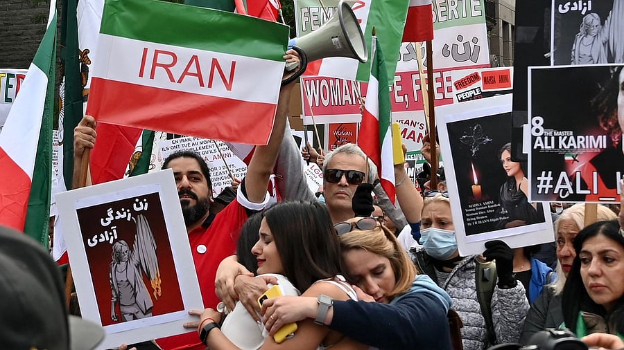 Women hug each other during a protest for Mahsa Amini. Credit: AFP Photo